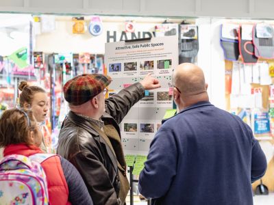 Member of the public adding their votes to a display board. 