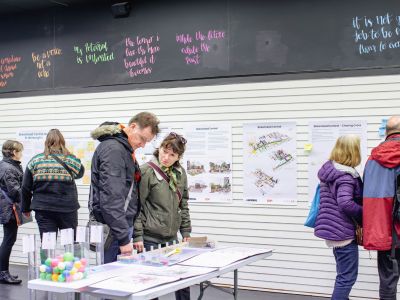 Members of the public viewing display boards and leaving comments in a temporary pop-up shop. 